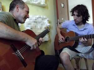 אוריאל אטלס מנגן על גיטרה עם תלמיד